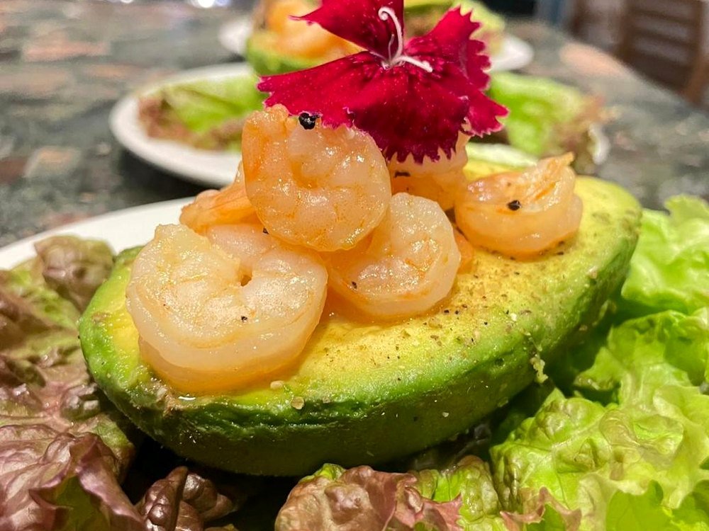 Costa Rica private chef appetizer - shrimp on avocado with edible flowers
