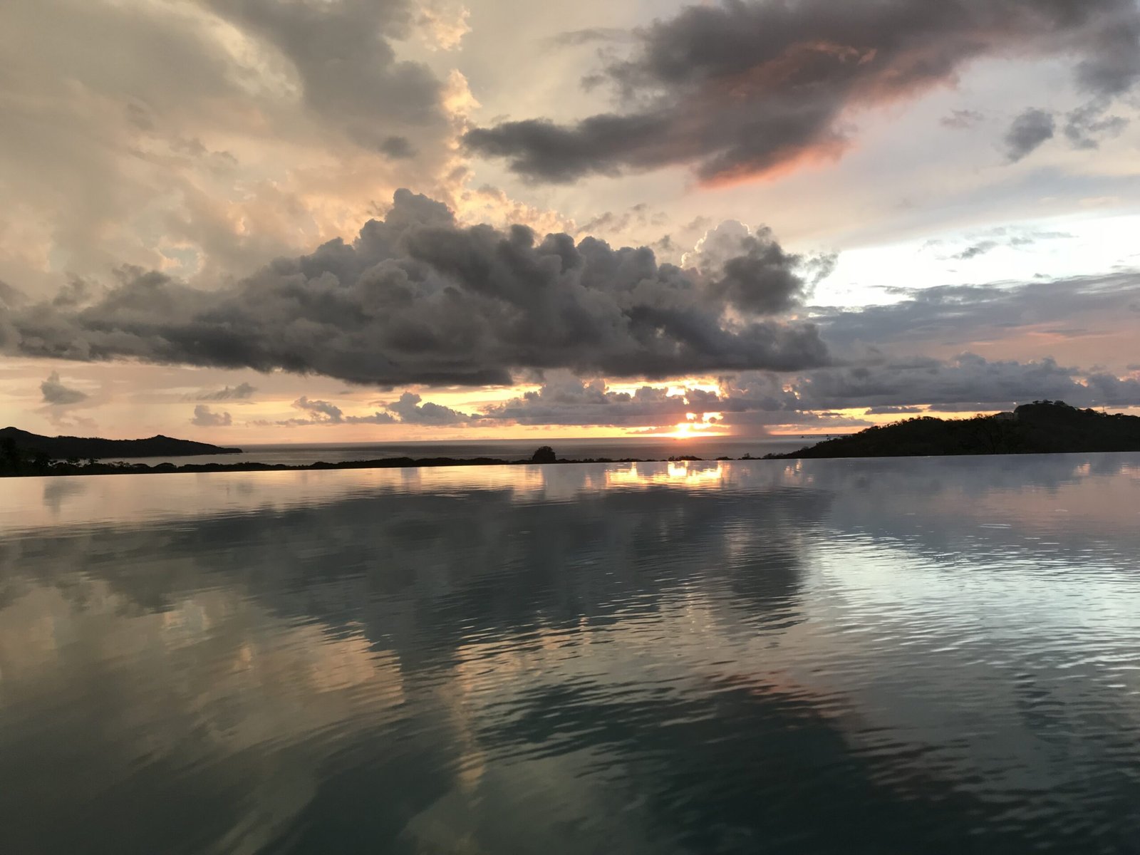 Playa Langosta Costa Rica - infinity pool sunset view over the Pacific