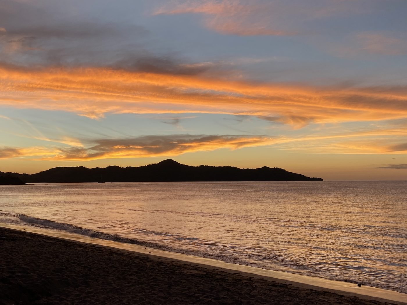 Golden sunset over a calm Guanacaste bay at the end of the drive from Liberia Airport to the Tamarindo Gold Coast
