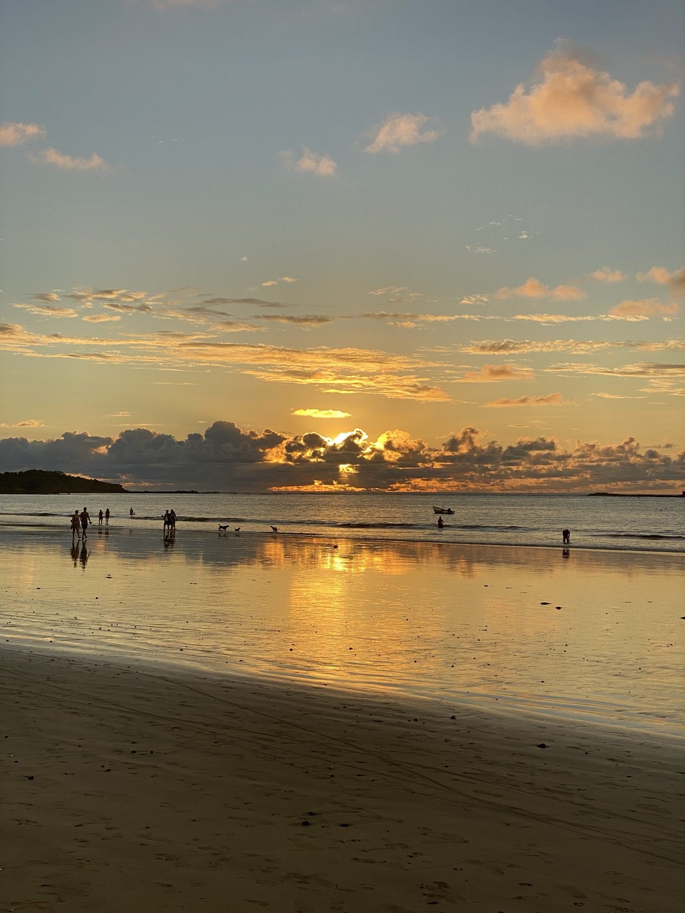 Wide flat beach at low tide near Tamarindo at sunset, showing the big Guanacaste tide swing that shapes the surf