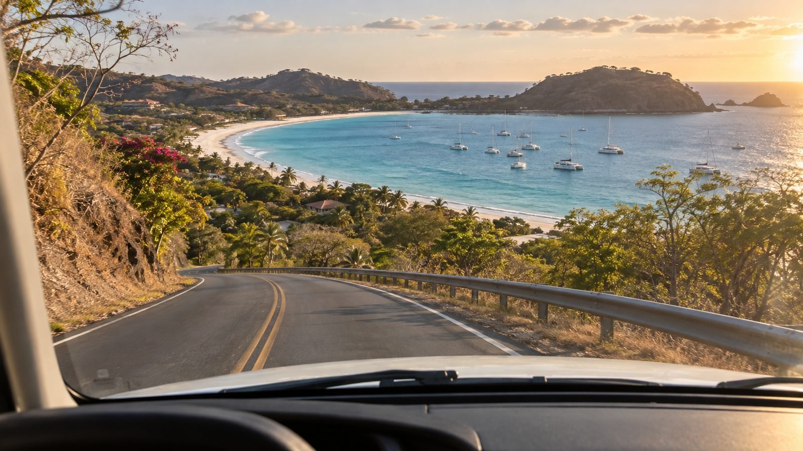 Paved coastal road descending toward the white sand bay of Playa Flamingo Costa Rica on the drive from Liberia Airport