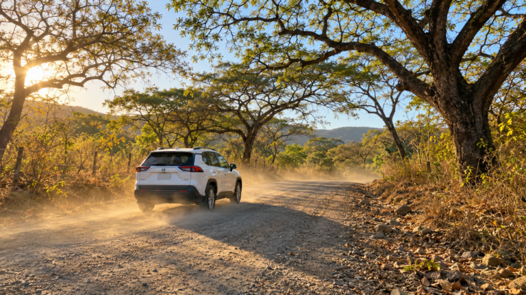 Rental SUV on a dusty gravel road through Guanacaste dry forest, the kind of side road where travelers ask if you need a 4x4 in Costa Rica